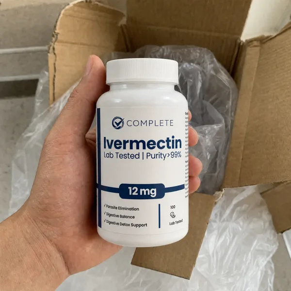 Customer holding a bottle of Complete Supplements Ivermectin with shipping boxes behind