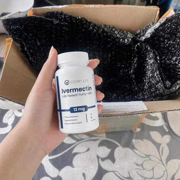 Customer holding a bottle of Complete Supplements Ivermectin over an open shipping box